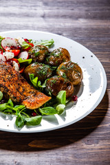 Grilled salmon, baked potatoes and vegetable salad