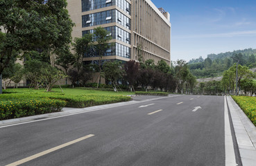 Fototapeta na wymiar empty asphalt road in the city, and office building.