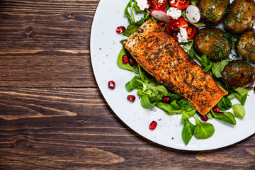 Grilled salmon, baked potatoes and vegetable salad