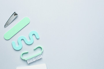 Top view of manicure and pedicure equipment on blue background with space for your text