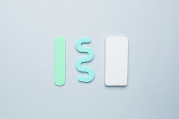 Pedicure manicure tools , nail file and separator for the fingers on blue background