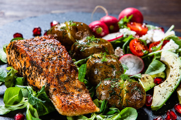 Grilled salmon, baked potatoes and vegetable salad