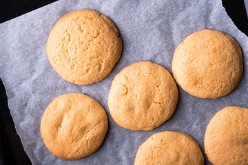 Homemade shortbread cookies on parchment paper in baking tray top view