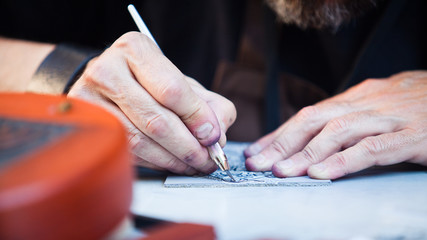 Engraver. Detail of hands of young craftman