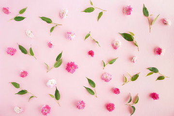 Flowers composition. Pattern made of  pink roses flowers and green leaves on pink background. Flat lay, top view.