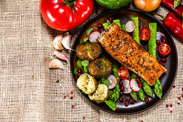 Grilled salmon, baked potatoes and vegetable salad