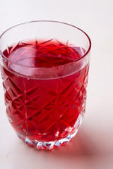 Stewed fruit red compote drink in textured transparent glass