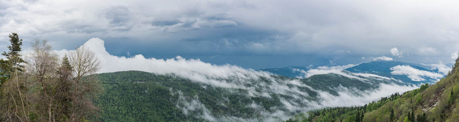 Foggy panorama of the gloomy plateau LagoNaki Adygea Republic with low clouds over the mountain peaks