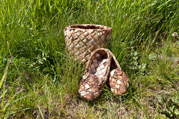 Braided bark sandals and braided birch bark box on the background of green grass