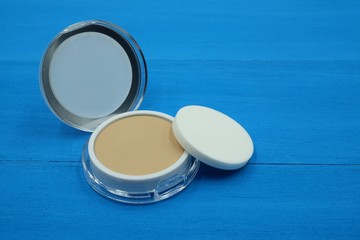 makeup face foundation powder on blue wooden background