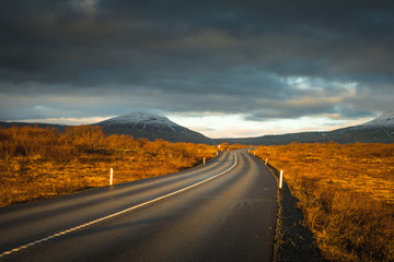 Landscape in Iceland waterfall sun mountains light golden hour road
