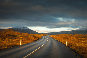 Landscape in Iceland waterfall sun mountains light golden hour road