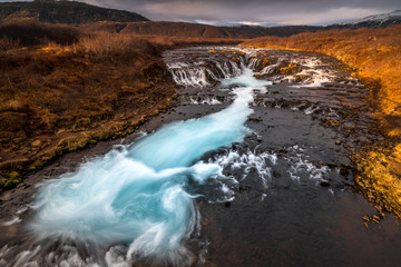 Landscape in Iceland waterfall sun mountains light golden hour road