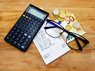 Checking a receipt. Calculator, glasses and money. Concept of purchase power