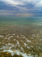 sea landscape is a pebbly beach with waves in white foam