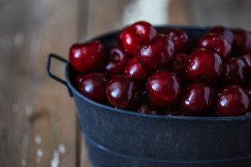 harvest of summer berries. Cherries in pails on a wooden table.