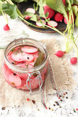 Pickled radish in a jar of herbs and garlic