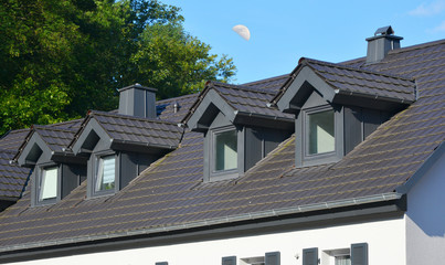 Dach mit Stehfalz-Metall verblendeten Sattelgauben und Schornstein