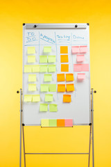 white office board with sticky notes and copy space isolated on yellow
