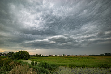 Storm cloud approaching over the dutch polder landscape between the cities of Gouda and Leiden, Holland