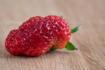 unusual shaped strawberry on a wooden table
