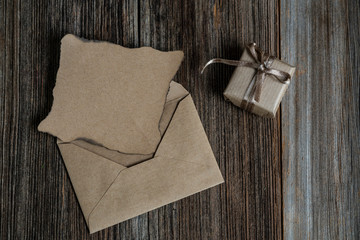 a blank letter and gift box on a wooden table