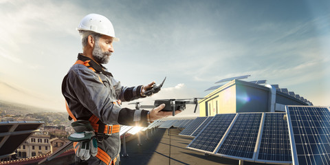 Happy engineer using drone for cheking solar station. in roof