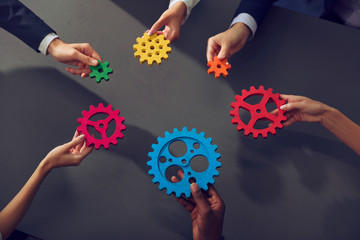 Business team connect pieces of gears. Teamwork, partnership and integration concept.