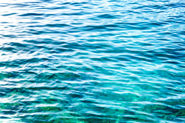 Turquoise surface of sea water with sun glare. Background.