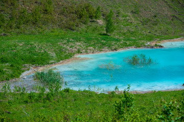 Naklejka na ściany i meble Alkaline solution. Ash dump dumping waste into the water. Ecological catastrophy. Turquoise dead water is like an oasis. The result of the waste plant.