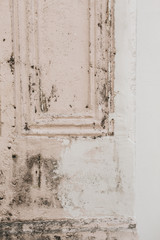 An old shabby pale pink and white door. Vintage and retro concept. Neutral background.