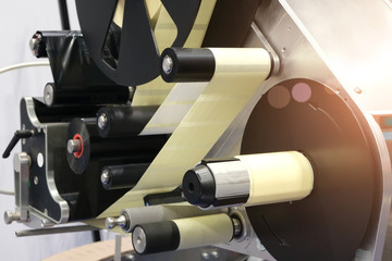 Fragment of the conveyor of sticking labeling machine. Abstract industrial background.
