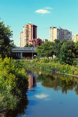 Fototapeta na wymiar Pond in the city park with buildings on a background. Summer image.
