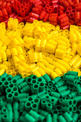 Obraz premium Plastic bricks of red, yellow and green. Details of toys. Close up.