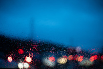 Blurred cars lights from inside a car with drops on the window