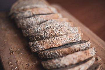 Sliced multigrain homemade bread on a wooden cutting board at home