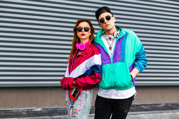 Back in time 90s 80s. Stylish young man in a retro jacket and a girl in red and with a vintage...