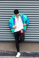 Back in time 90s 80s. Stylish young man in a retro jacket and with a vintage cassette player, on...