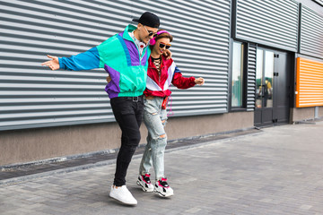 Back in time 90s 80s. Stylish young man in a retro jacket and a girl in red and with a vintage...
