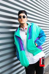 Back in time 90s 80s. Stylish young man in a retro jacket and with a vintage cassette player, on...