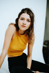 portrait of confident brunette woman wearing a yellow top