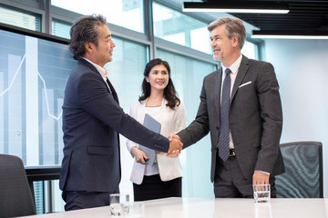 Business people shaking hands in conference room