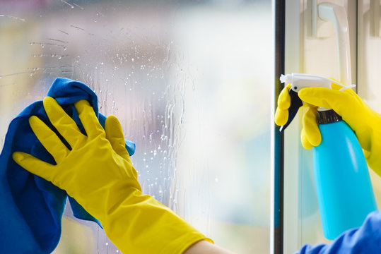 Gloved Hand Cleaning Window Rag And Spray