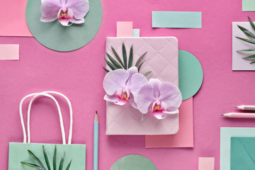 Floral paper background in pink and mint colors. Orchid flowers on geometric background with copy-space.