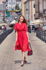 Cute girl walks in the middle of the street in sunny day