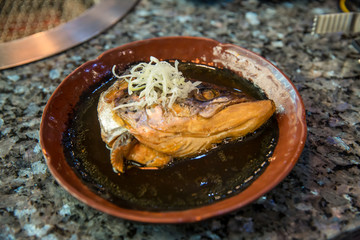 apanese food concept. Salmon head steamed with sweet sauce and vegetable in Japanese style. Salmon kabutoni steamed, Japanese food style. Salmon head boiled in soy sauce with vegetables. 