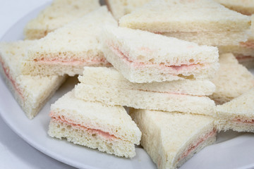 Many mini sandwhiches on a plate.