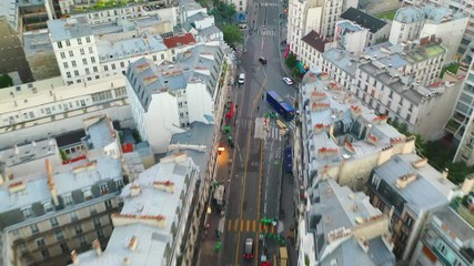 Aerial, tilt up, drone shot, over traffic on a french street, surrounded by buildings and architecture, in the city of Paris, on a sunny, summer day, in France