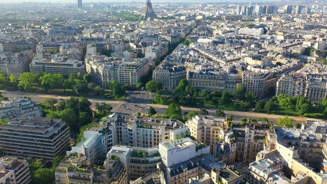 Aerial, tilt up, drone shot, revealing traffic on Avenue Foch, french buildings, architecture and the Eiffel tower, in the city of Paris, on a sunny, summer day, in France
