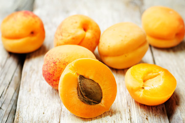 Naklejka na ściany i meble apricots with slices on a wooden background